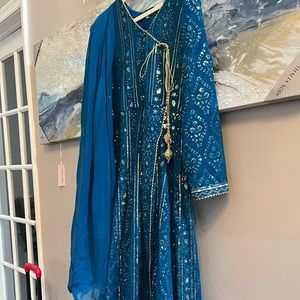 It is a beautiful and delicate angarkha dress . Teal color medium to large size.